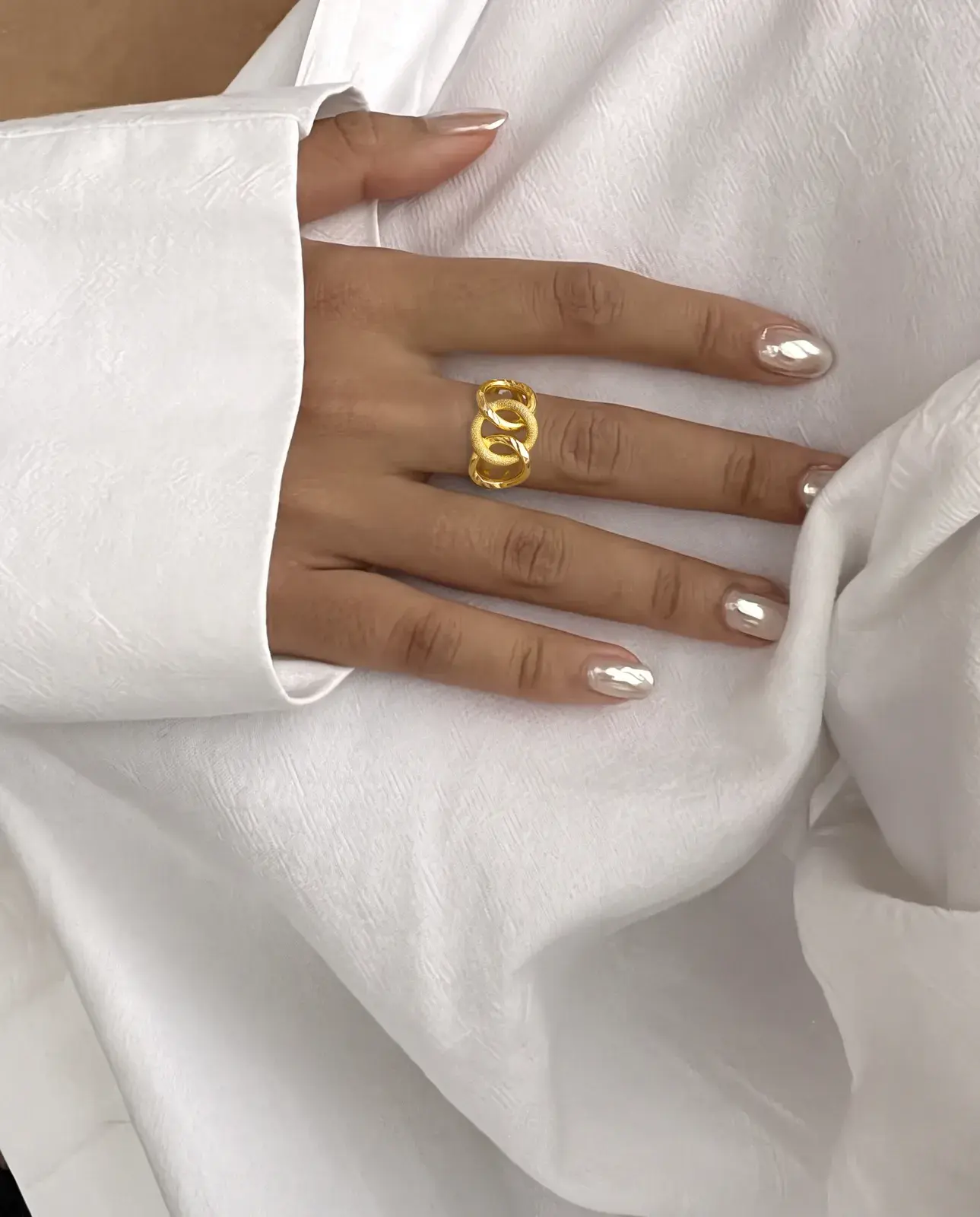 A model wearing the Linked Loops Ring in 21K yellow gold