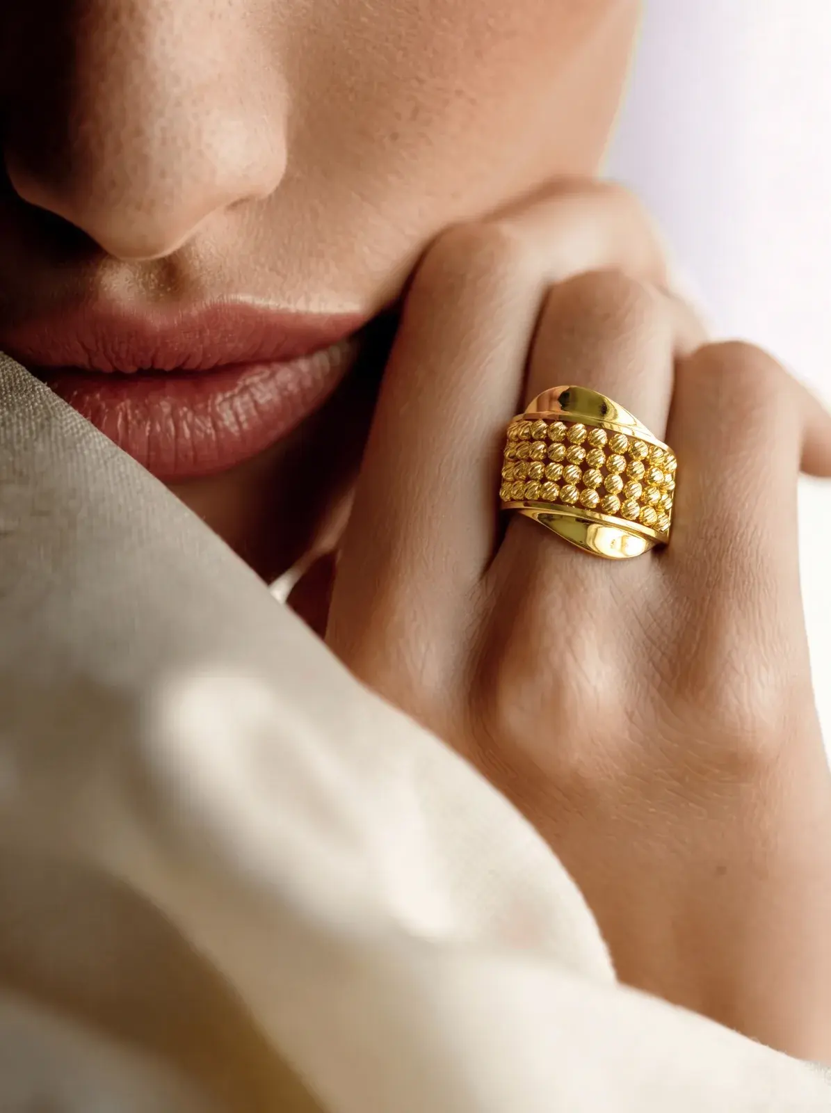 A model wearing the Beaded Panel Ring in 21K yellow gold